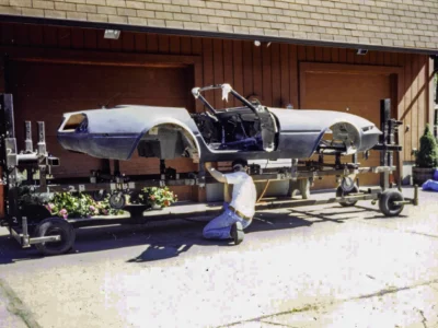 Technician working on McBurnie Daytona Spyder body at Corvette Connection shop door in Bolton CT