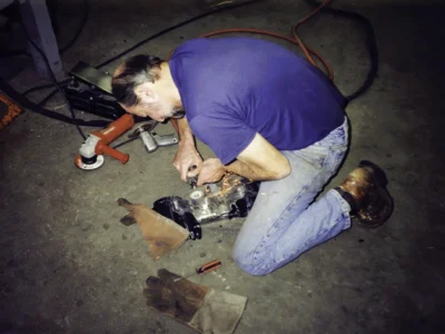 Technician working underneath McBurnie Daytona Spyder during chassis assembly at Corvette Connection