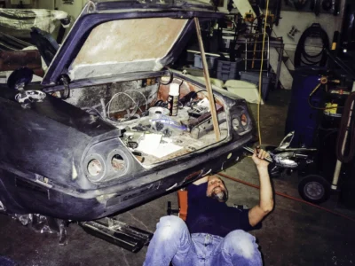 Technician working inside McBurnie Daytona Spyder trunk area during body assembly