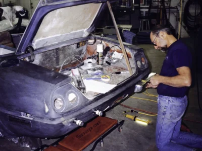 Technician fitting McBurnie Daytona Spyder hood and front body panels at Corvette Connection