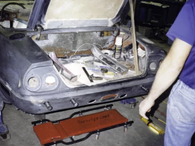 Technician working on McBurnie Daytona Spyder rear panel and taillight area at Corvette Connection
