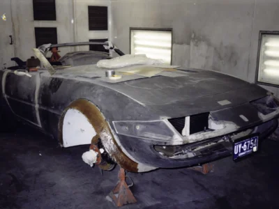 McBurnie Daytona Spyder body in primer rear three-quarter on jack stands at Corvette Connection