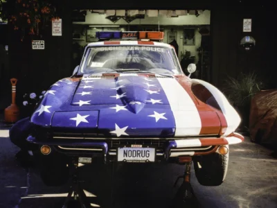 Remastered photo of a patriotic red, white, and blue 1970s Chevrolet Corvette pace car front view inside the Corvette Connection shop in Bolton, Connecticut.