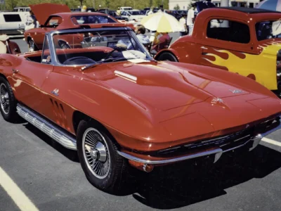 Remastered photo of a red 1965 Chevrolet Corvette convertible rear side angle at a car show by Corvette Connection in Bolton, Connecticut.