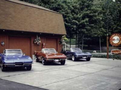 Remastered photo of multiple classic Chevrolet Corvettes parked outside Corvette Connection in Bolton, Connecticut, showing a lineup of restored vehicles in front of the shop building.