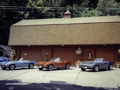 Remastered photo of blue, red, and black classic Chevrolet Corvettes parked outside Corvette Connection in Bolton, Connecticut, showing a restored vehicle lineup in front of the shop.