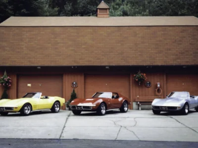 Remastered photo of a Corvette Connection shop lineup with yellow, red, and silver classic Chevrolet Corvettes parked in front of the Bolton, Connecticut restoration building.