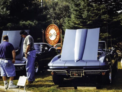 Remastered photo of a blue 1966 Chevrolet Corvette convertible with hood open beside the Corvette Connection sign at a local car show in Bolton, Connecticut.