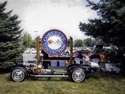 Remastered photo of a 1957 Chevrolet Corvette restoration chassis displayed at a car show with the Corvette Connection sign in Bolton, Connecticut.